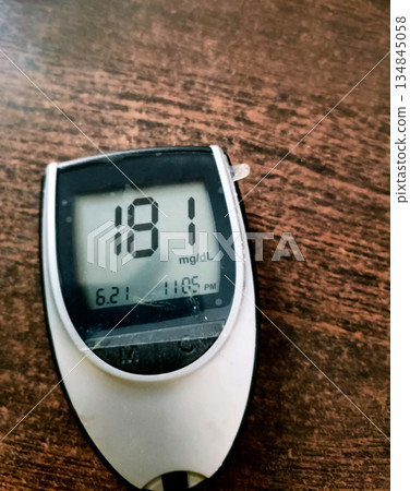 A close up of blood glucose meter with high sugar reading on wood 134845058