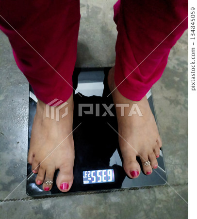 Woman Checking Weight on Digital Weighing Scale 134845059