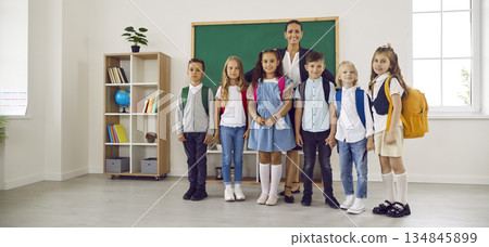 Teacher with group of elementary students in classroom, backpacks, back to school Teacher with group of elementary students in classroom, backpacks, back to school 134845899
