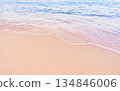 Soft blue ocean waves gently lapping onto a pristine tropical sandy beach 134846006
