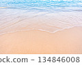 Soft blue ocean waves gently lapping onto a pristine tropical sandy beach 134846008