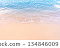 Soft blue ocean waves gently lapping onto a pristine tropical sandy beach 134846009