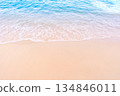 Soft blue ocean waves gently lapping onto a pristine tropical sandy beach 134846011