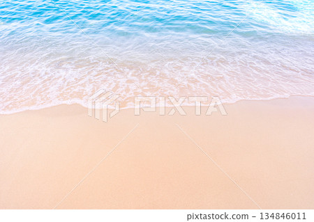 Soft blue ocean waves gently lapping onto a pristine tropical sandy beach 134846011
