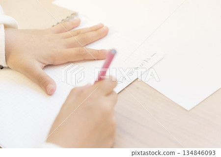 Close-up of a child's hands writing letters (learning image) Close-up of a child's hands writing letters (learning image) 134846093