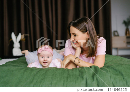 Happy Mother And Baby Girl Lying On Bed At Home 134846225