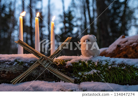 Wiccan altar for Imbolc holiday. Brigids cross of straw, candles, witch doll ram/sheep on snow. witchcraft, magic pagan ritual. Wiccan altar for Imbolc holiday. Brigids cross of straw, candles, witch doll ram/sheep on snow. witchcraft, magic pagan ritual. 134847274