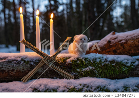 Wiccan altar for Imbolc holiday. Brigids cross of straw, candles, witch doll ram/sheep on snow. witchcraft, magic pagan ritual. 134847275