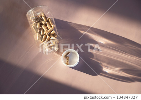 Brown pills in clear plastic bottle and on white cap. Brown pills in clear plastic bottle and on white cap. 134847327