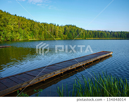 A bridge for swimming on a perfectly clean smooth calm lake in the morning. A bridge for swimming on a perfectly clean smooth calm lake in the morning. 134848014