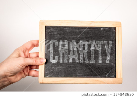 CHARITY Concept Displayed On Chalkboard Held By Human Hand 134848650