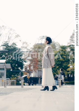 一位三十多歲女性的全身肖像，她站在戶外。 134849598