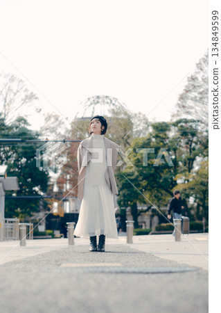 一位三十多歲女性的全身肖像，她站在戶外。 134849599