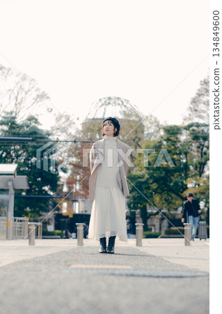 Full-body portrait of a woman in her 30s standing outdoors Full-body portrait of a woman in her 30s standing outdoors 134849600
