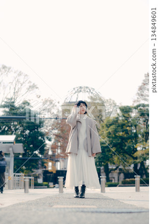Full-body portrait of a woman in her 30s standing outdoors Full-body portrait of a woman in her 30s standing outdoors 134849601