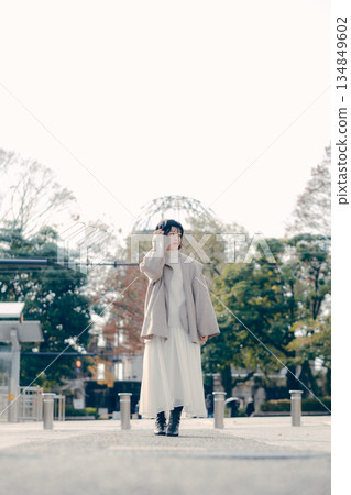 Full-body portrait of a woman in her 30s standing outdoors 134849602