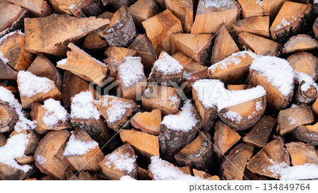 Stacked Firewood Dusted With Fresh Snow, Rustic Cabin Supply Captured In Crisp Winter Light, Rough Cut Log Faces, Warm Brown Tones, Tactile Bark Textures, Seasonal Preparation And Cozy Hygge 134849764