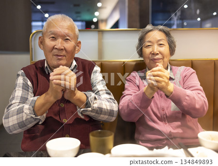 Happy Asian senior couple celebrating Chinese New Year in restaurant 134849893