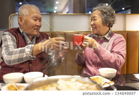 Happy Asian senior couple celebrating Chinese New Year in restaurant Happy Asian senior couple celebrating Chinese New Year in restaurant 134849897