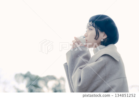 一位三十多歲的女性在戶外喝咖啡的生活方式肖像 一位三十多歲的女性在戶外喝咖啡的生活方式肖像 134851252