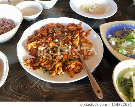 Spicy Korean Jjukkumi Stir Fry with Vegetables Served as a Traditional Korean Main Dish on a Wooden Table 134852685