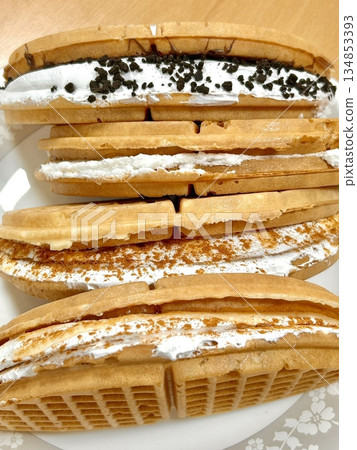 Crispy, golden waffles topped with creamy ice cream, creating a perfect balance of warm and cold, crunchy and smooth. A delightful dessert or breakfast treat, with toppings like fruits or syrup. Crispy, golden waffles topped with creamy ice cream, creating a perfect balance of warm and cold, crunchy and smooth. A delightful dessert or breakfast treat, with toppings like fruits or syrup. 134853393