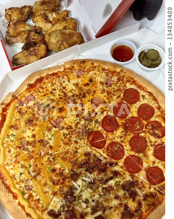Crispy Korean fried chicken with bold, spicy glaze served alongside cheesy, oven-baked pizza. A flavorful fusion of Korean heat and classic comfort for the ultimate indulgent treat. 134853489