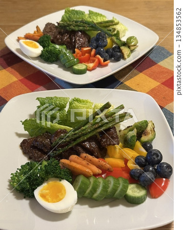 Fresh salad with a mix of crisp leafy greens, sliced vegetables, and colorful ingredients, tossed together to create a healthy, vibrant, and refreshing dish full of natural flavors 134853562