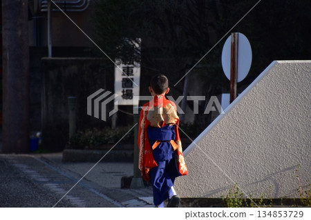 Inuyama City, Aichi Prefecture, Japan - A boy participating in the spring Inuyama Festival, wearing a traditional kimono, walking down an alleyway Inuyama City, Aichi Prefecture, Japan - A boy participating in the spring Inuyama Festival, wearing a traditional kimono, walking down an alleyway 134853729