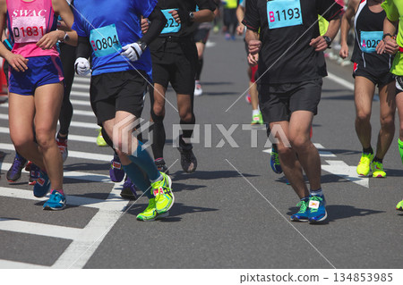 The dynamic movement of the feet and running shoes of amateur runners running smoothly in a marathon The dynamic movement of the feet and running shoes of amateur runners running smoothly in a marathon 134853985