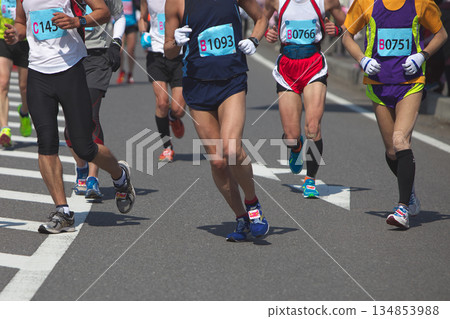 The dynamic movement of the feet and running shoes of amateur runners running smoothly in a marathon The dynamic movement of the feet and running shoes of amateur runners running smoothly in a marathon 134853988