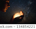 Beautiful star background with shining star in the hands of a praying person 134854221