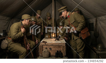 日本軍官和士兵在帳篷裡舉行戰略會議,並展開地圖。 日本軍官和士兵在帳篷裡舉行戰略會議,並展開地圖。 134854292