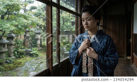 一位身穿和服的女子站在雨中的窗邊,手裡緊緊握著一根千人針,為奔赴戰場的丈夫祈禱平安。 一位身穿和服的女子站在雨中的窗邊,手裡緊緊握著一根千人針,為奔赴戰場的丈夫祈禱平安。 134854294