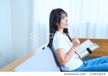 一位日本女性打開筆記本，思考著…（畫面內容：想法、未來計畫與學習） 134854628