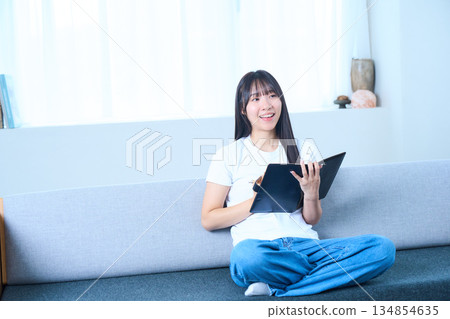 A Japanese woman opening a notebook and thinking Image of ideas, future plans, and studying A Japanese woman opening a notebook and thinking Image of ideas, future plans, and studying 134854635