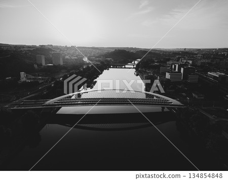 Troja Bridge stands over the Vltava River in Prague as the sun rises. The scene shows the calm waters below and the cityscape in the background. This view captures early morning light. Troja Bridge stands over the Vltava River in Prague as the sun rises. The scene shows the calm waters below and the cityscape in the background. This view captures early morning light. 134854848