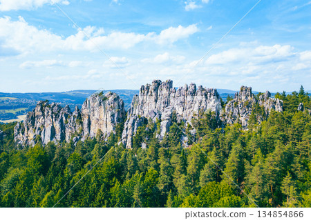 Explore the stunning sandstone formations at Suche skaly in Czechia's Bohemian Paradise. Surrounded by lush greenery, these natural structures create a breathtaking view. 134854866