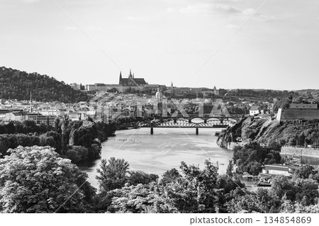 Breathtaking view of Prague skyline including Prague Castle, with the Vltava River flowing beneath. Lush greenery surrounds the riverbank, capturing the city charm on a clear day. Breathtaking view of Prague skyline including Prague Castle, with the Vltava River flowing beneath. Lush greenery surrounds the riverbank, capturing the city charm on a clear day. 134854869