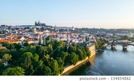A breathtaking view of Prague at sunrise, showcasing the Vltava River, medieval architecture, and the famous Charles Bridge. The tranquil morning light enhances the city's beauty. A breathtaking view of Prague at sunrise, showcasing the Vltava River, medieval architecture, and the famous Charles Bridge. The tranquil morning light enhances the city's beauty. 134854882