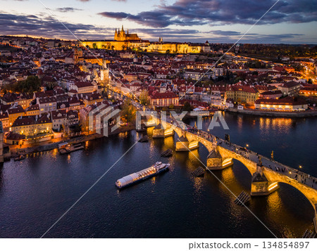 Prague Castle and Charles Bridge at night. Lights illuminate the castle and bridge, creating a beautiful view over the Vltava River in Prague, Czechia. 134854897