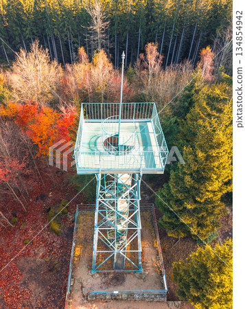 Slovanka Lookout Tower stands tall in the Jizera Mountains, showcasing stunning autumn foliage. Visitors can enjoy panoramic views from this historic iron structure surrounded by colorful trees. Slovanka Lookout Tower stands tall in the Jizera Mountains, showcasing stunning autumn foliage. Visitors can enjoy panoramic views from this historic iron structure surrounded by colorful trees. 134854942