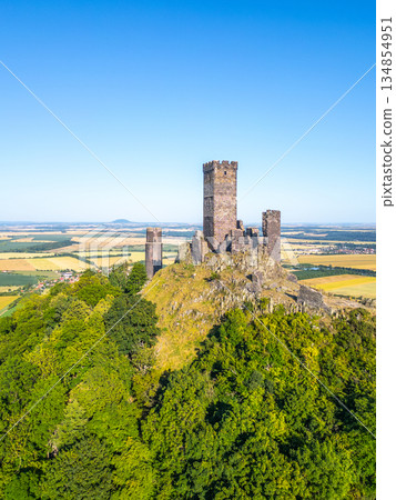 Hazmburk castle ruins rise majestically in Czechia's Central Bohemian Uplands. This medieval marvel offers breathtaking views over the lush green hills and fields below. Hazmburk castle ruins rise majestically in Czechia's Central Bohemian Uplands. This medieval marvel offers breathtaking views over the lush green hills and fields below. 134854951