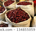 Large Sacks of Dried Red Chilies for Kimchi Making, Traditional Korean Kimchi Pepper Harvest in Market Bags, Closeup Texture and Vibrant Color for Culinary and Food Production Use 134855059
