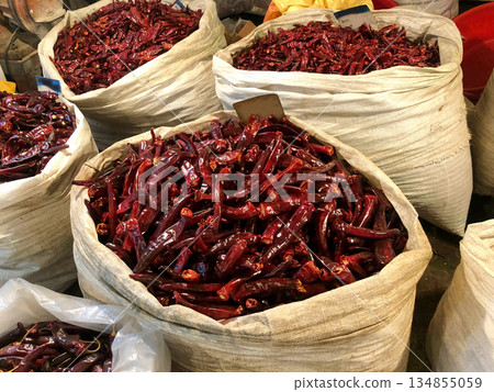 Large Sacks of Dried Red Chilies for Kimchi Making, Traditional Korean Kimchi Pepper Harvest in Market Bags, Closeup Texture and Vibrant Color for Culinary and Food Production Use 134855059