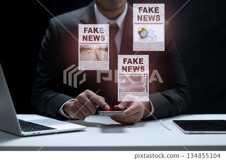 Businessman in a suit uses a smartphone to consume news, and is surrounded by fake news publications on the screen. Concept of fake news 134855104