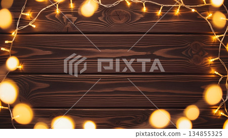 Warm Glowing Christmas Lights Frame on Dark Wooden Background Warm Glowing Christmas Lights Frame on Dark Wooden Background 134855325