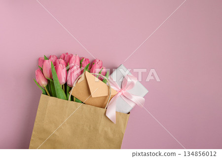 Gift Bag with Pink Tulips and Gift Box on Pink Background. Valentine's or Mother's Day Celebration 134856012