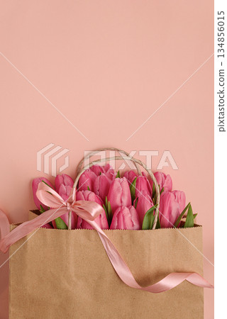 Gift Bag with Pink Tulips on Pink Background. Valentine's or Mother's Day Celebration 134856015