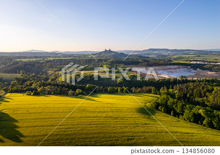 Visitors can enjoy the scenic views of Bohemian Paradise during summer. The landscape features Trosky Castle overlooking green fields and surrounding forests in Czechia. Visitors can enjoy the scenic views of Bohemian Paradise during summer. The landscape features Trosky Castle overlooking green fields and surrounding forests in Czechia. 134856080